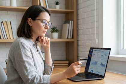 Femme analysant des solutions de paiement en ligne sur un ordinateur portable dans un bureau moderne